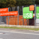 Ein Zaun mit Aufschrift Wertstoffhof Blücherstrasse und USB