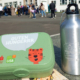 Eine Brotdose des USBs und eine Flasche der Powerpiraten stehen auf einem Schulhof. Im Hintergrund sind Schüler zu erkennen