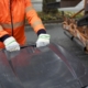 Ein orange gekleideter Müllmann schiebt eine schwarze Tonne