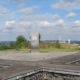 eine Kreuzförmige Holzbank auf der Spitze des Tippels Berges mit einer Aussicht über Bochum