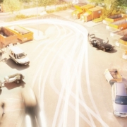 Auf einer Asphaltfläche stehen mehrere Fahrzeuge und am Rand mehrere orangene Container