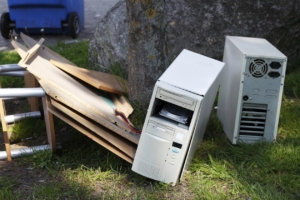 Sperrmüll, welcher an einem Baum liegt. Zu sehen sind Computer und Holzmüll