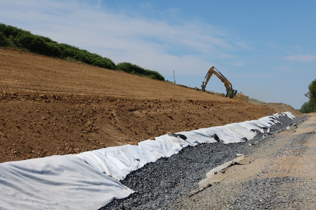 Ein Bagger fährt einen Sandhügel hinauf