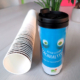 Blauer Becher mit Augen steht neben liegenden Kaffeebecher