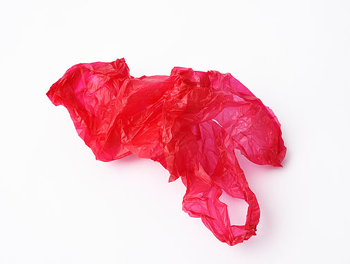 Rote Plastiktüte liegt auf dem Boden