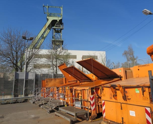 Orangene Container stehen auf einem Wertstoffhof
